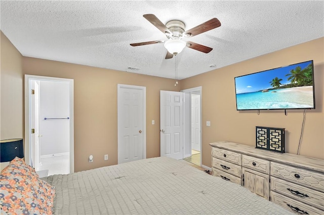 bedroom with ceiling fan and a textured ceiling