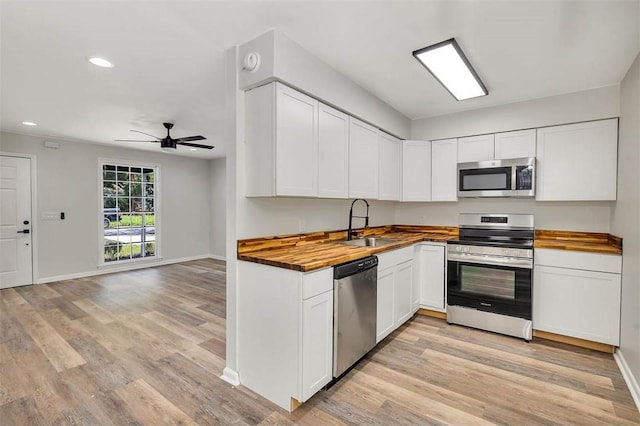 158 Yorktown Dr, Brunswick, GA 31525 - kitchen with sink, light wood-type flooring, appliances with stainless steel finishes, butcher block countertops, and white cabinetry