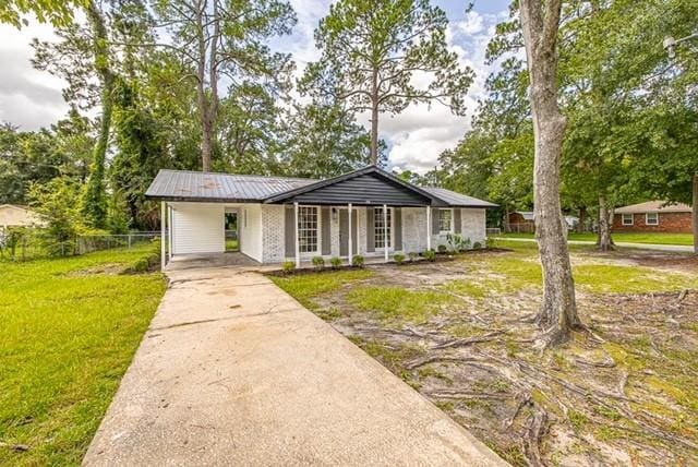 ranch-style home featuring a front lawn, a porch, and a carport