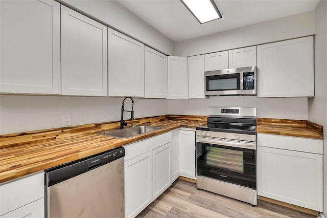 158 Yorktown Dr, Brunswick, GA 31525 - kitchen with butcher block countertops, sink, white cabinets, and stainless steel appliances