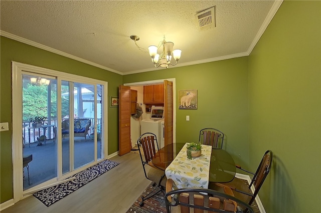 1622 Booth St, Waycross, GA 31501 - dining space with a chandelier, washer / dryer, wood finished floors, ornamental molding, and a textured ceiling