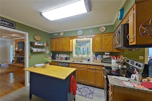 1622 Booth St, Waycross, GA 31501 - kitchen featuring appliances with stainless steel finishes, a sink, crown molding, wood counters, and healthy amount of natural light