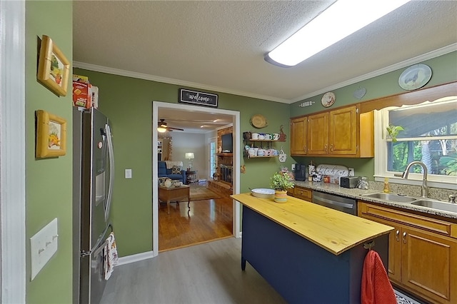 1622 Booth St, Waycross, GA 31501 - kitchen featuring butcher block countertops, stainless steel appliances, a sink, light wood finished floors, and crown molding