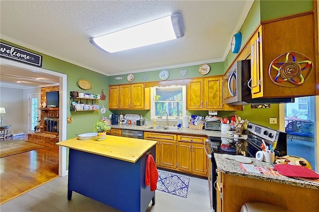 1622 Booth St, Waycross, GA 31501 - kitchen featuring a sink, appliances with stainless steel finishes, crown molding, brown cabinets, and a textured ceiling