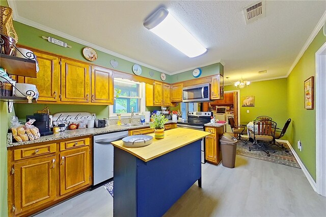 1622 Booth St, Waycross, GA 31501 - kitchen featuring appliances with stainless steel finishes, light wood-type flooring, a sink, crown molding, and a chandelier