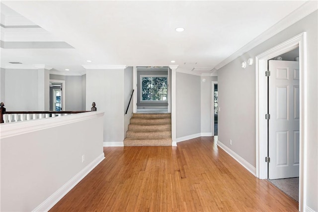 hallway with light hardwood / wood-style flooring and crown molding