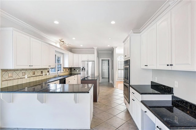 kitchen featuring stainless steel appliances, white cabinets, kitchen peninsula, light tile patterned flooring, and ornamental molding