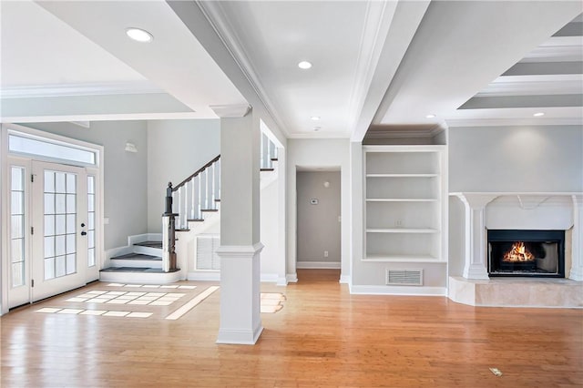 unfurnished living room with crown molding, a fireplace, and light hardwood / wood-style floors