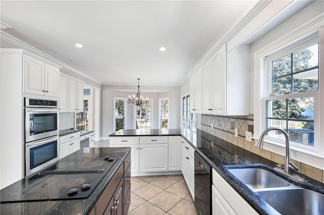 kitchen featuring white cabinets, an inviting chandelier, a healthy amount of sunlight, and sink