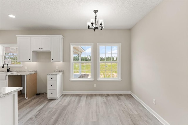 4432 Pembers Rd, Nahunta, GA 31553 - kitchen featuring a chandelier, light wood-style flooring, white cabinetry, a textured ceiling, and recessed lighting