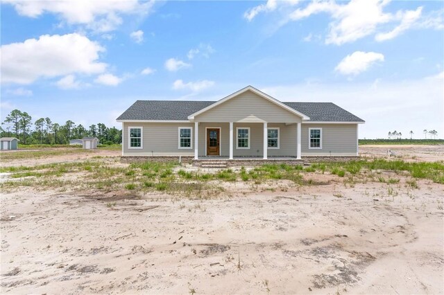 4432 Pembers Rd, Nahunta, GA 31553 - ranch-style house featuring a porch, a shed, and a shingled roof
