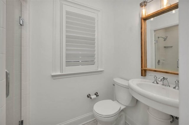 bathroom with toilet, an enclosed shower, and sink