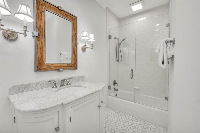 bathroom featuring vanity and combined bath / shower with glass door