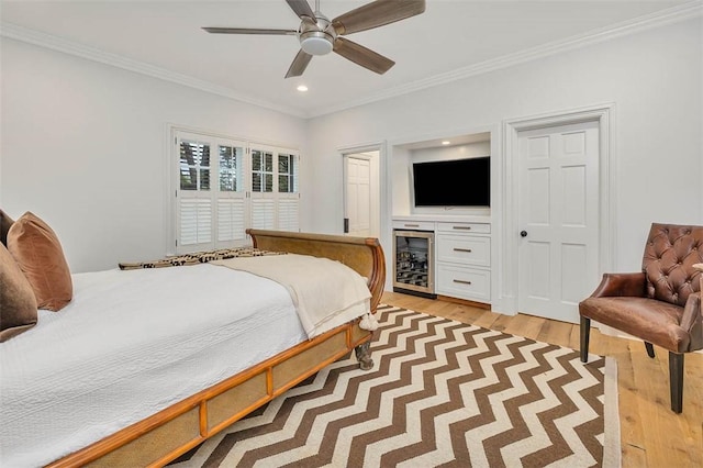 bedroom with wine cooler, light hardwood / wood-style flooring, ceiling fan, and ornamental molding