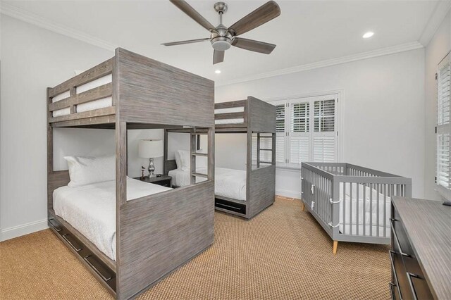 carpeted bedroom featuring ceiling fan and crown molding