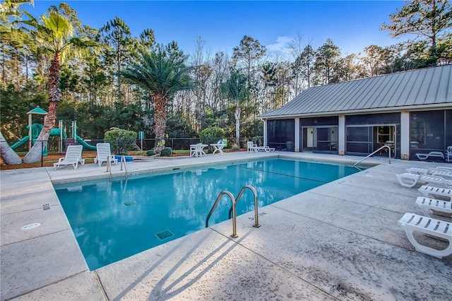 259 Daniel Trent Way, Kingsland, GA 31548 - community pool featuring a sunroom, a patio area, view of scattered trees, and a playground
