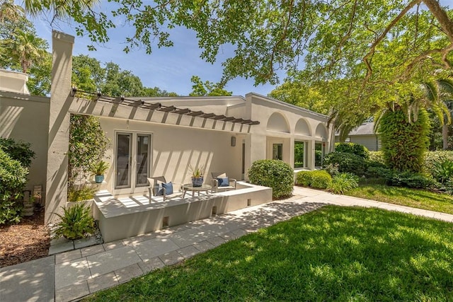 4218 Fifth St, Saint Simons Island, GA 31522 - back of property with stucco siding, a patio, and a yard