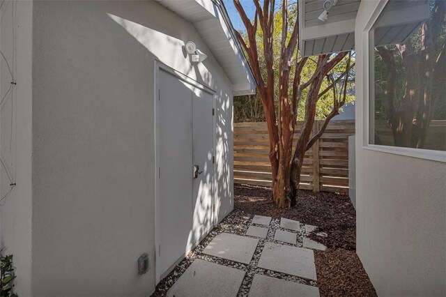 view of home's exterior with an outbuilding, a storage shed, fence, and stucco siding