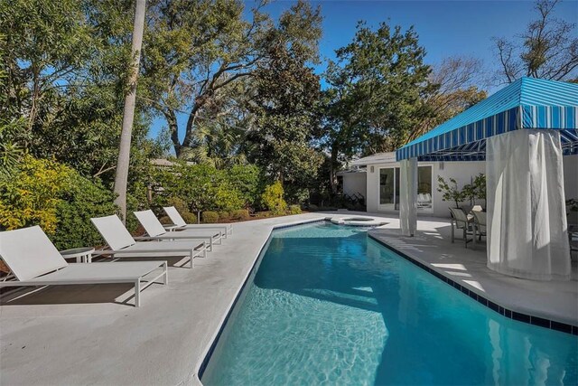 view of pool with a pool with connected hot tub and a patio