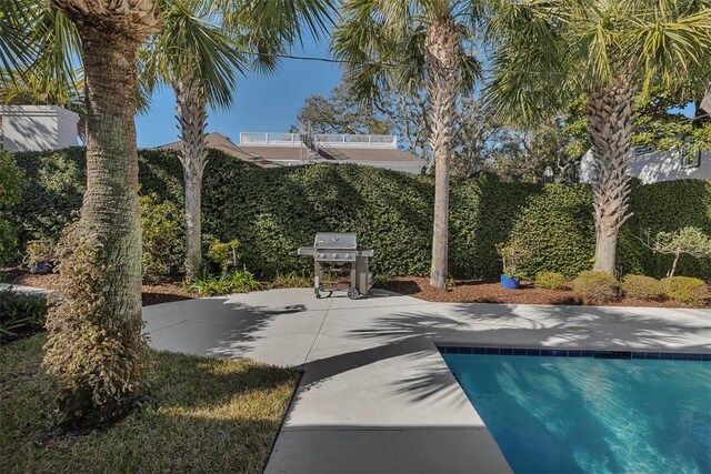 exterior space with a pool, a patio, and area for grilling