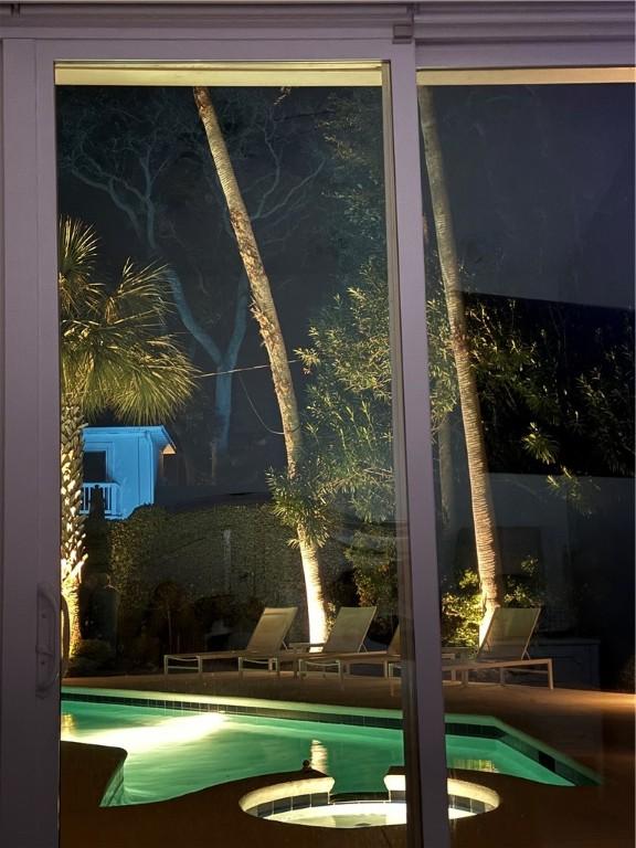 4218 Fifth St, Saint Simons Island, GA 31522 - pool at night with a pool with connected hot tub