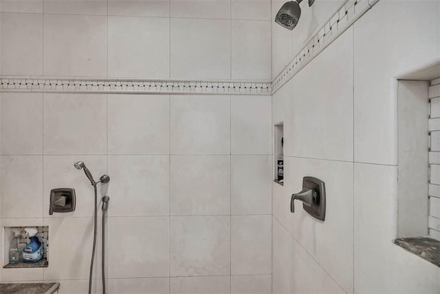 interior details featuring tiled shower