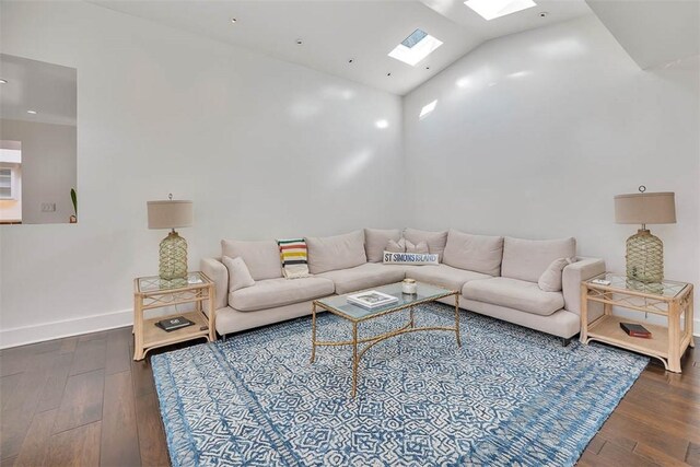 living area with dark wood-style floors, lofted ceiling with skylight, and baseboards