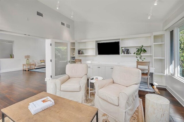 living area with a wealth of natural light, baseboards, visible vents, and dark wood-style flooring