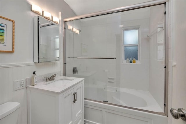 bathroom with enclosed tub / shower combo, vanity, and toilet