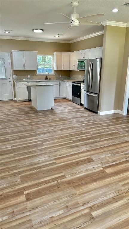 kitchen featuring a center island, sink, appliances with stainless steel finishes, light hardwood / wood-style floors, and white cabinetry