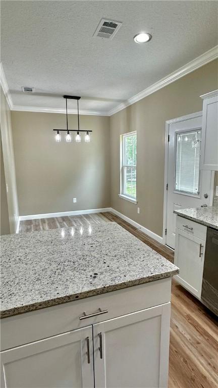 kitchen with white cabinetry, ornamental molding, pendant lighting, and light hardwood / wood-style floors