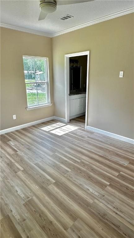 empty room with light wood-type flooring, ceiling fan, and crown molding