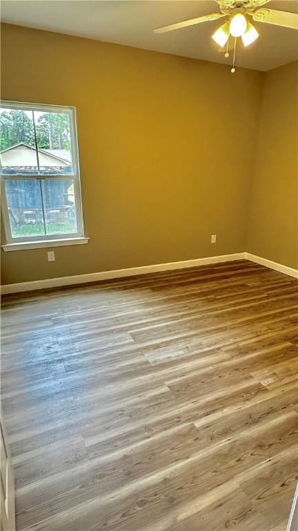 spare room with hardwood / wood-style floors and ceiling fan