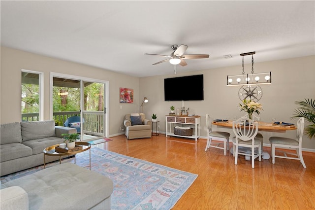 living room with light hardwood / wood-style floors and ceiling fan