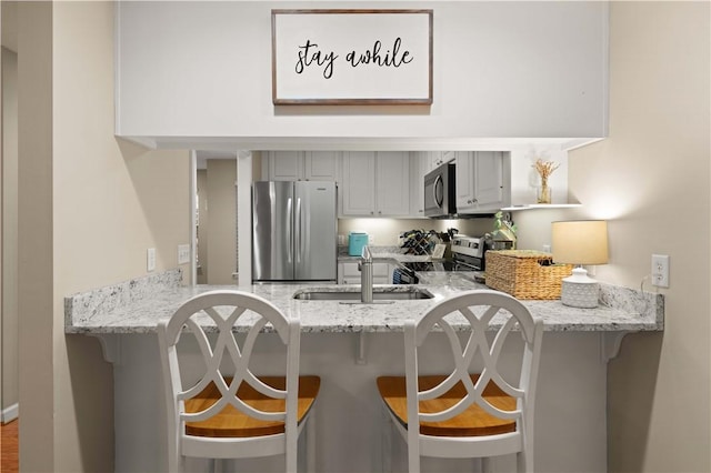 kitchen with stainless steel appliances, a breakfast bar, and kitchen peninsula