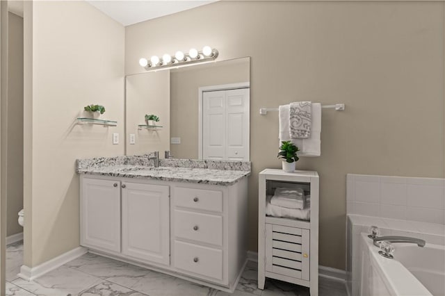 bathroom featuring vanity, toilet, and a tub