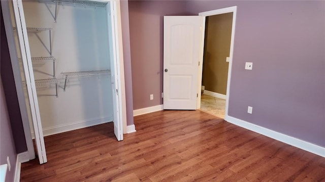 unfurnished bedroom featuring hardwood / wood-style floors and a closet