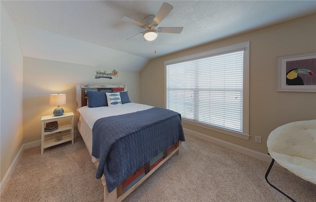 bedroom with light carpet, ceiling fan, vaulted ceiling, and a textured ceiling