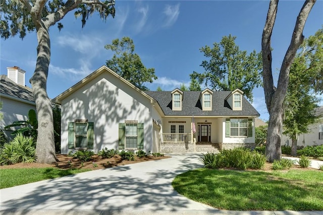 view of front of house with covered porch and a front lawn