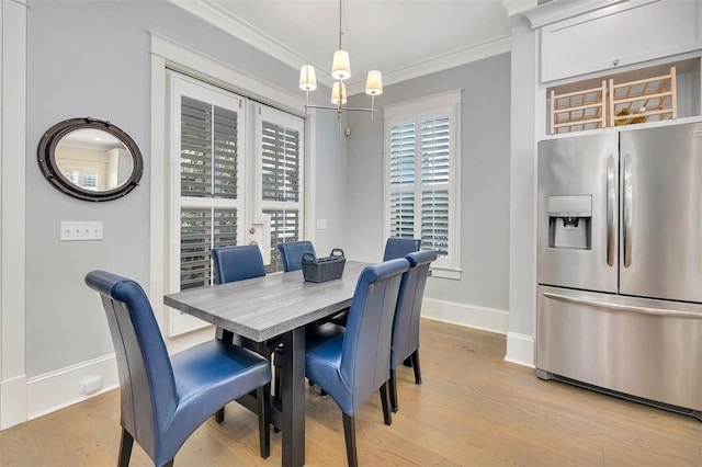 dining area with light wood finished floors, a chandelier, baseboards, and ornamental molding