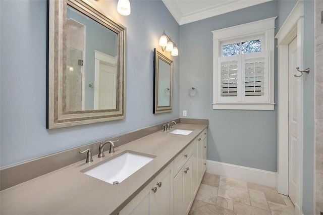 bathroom with a sink, baseboards, double vanity, and crown molding