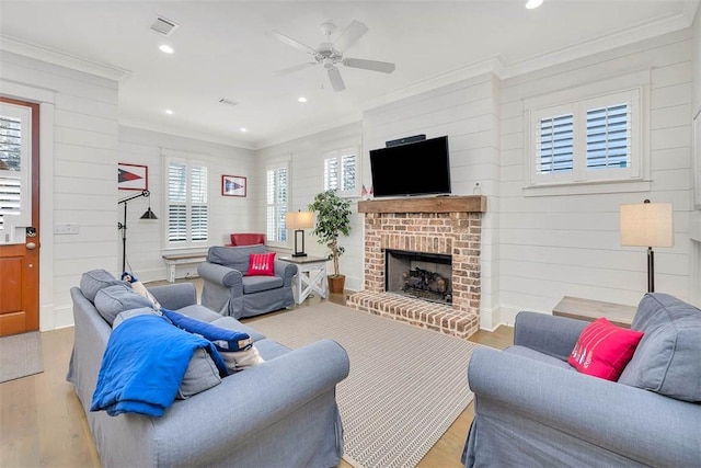 living room featuring visible vents, wood finished floors, recessed lighting, a fireplace, and crown molding