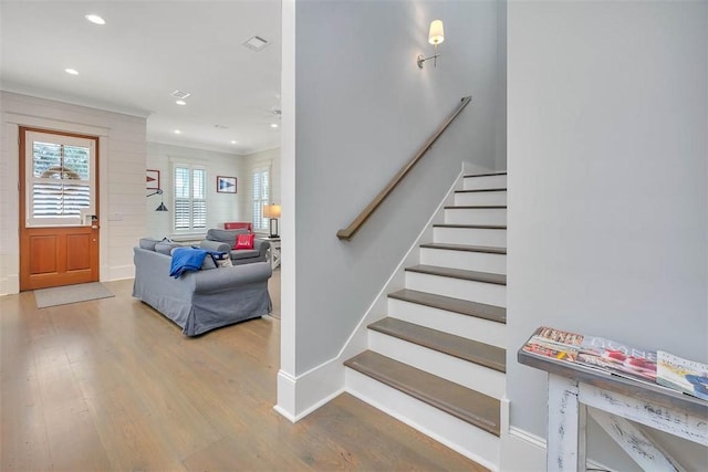 stairway featuring visible vents, wood finished floors, recessed lighting, crown molding, and baseboards