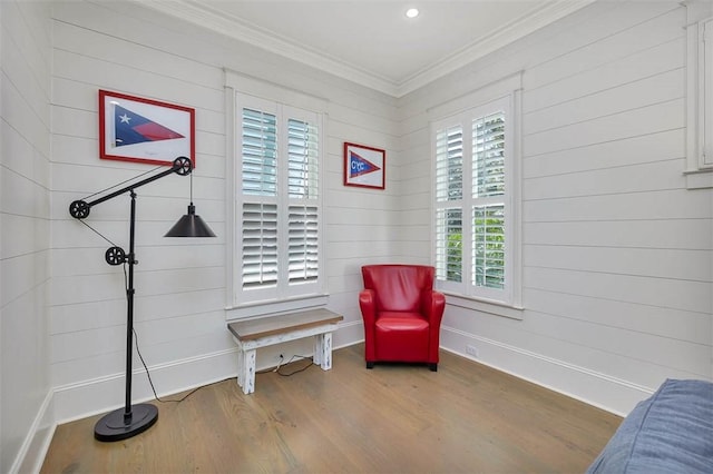 living area with crown molding, recessed lighting, wood finished floors, and baseboards