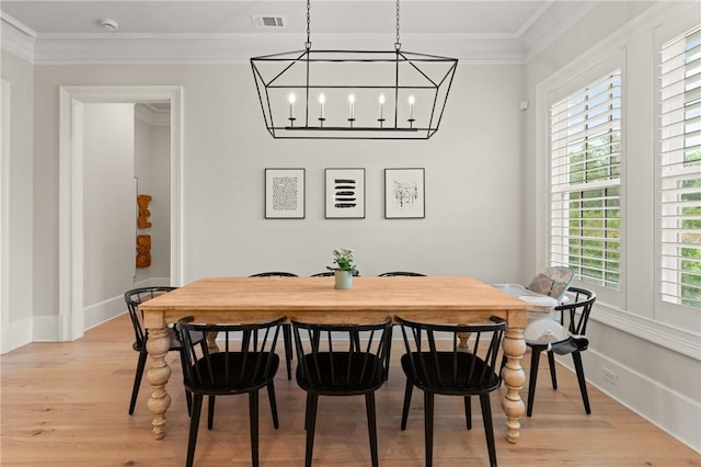 166 Robertson Cir, Saint Simons Island, GA 31522 - dining space featuring crown molding, light wood finished floors, a chandelier, and baseboards