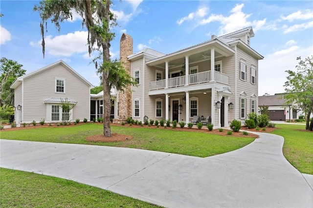 166 Robertson Cir, Saint Simons Island, GA 31522 - view of front of house with a balcony, ceiling fan, a front yard, and a chimney