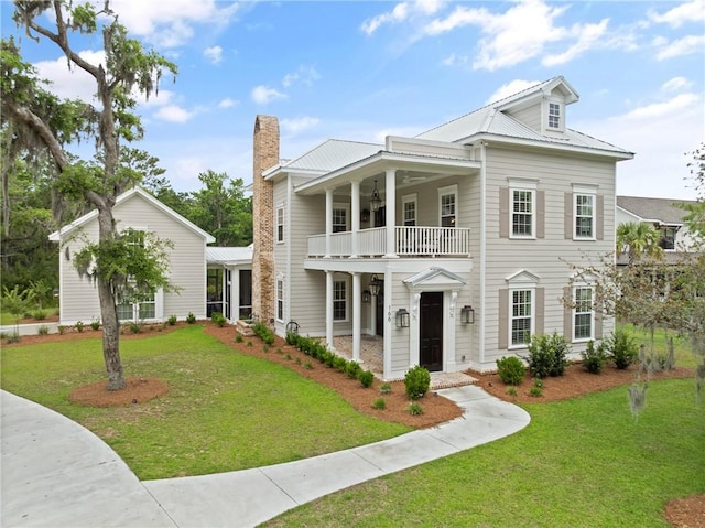 166 Robertson Cir, Saint Simons Island, GA 31522 - greek revival inspired property featuring a balcony, ceiling fan, a front yard, and a chimney