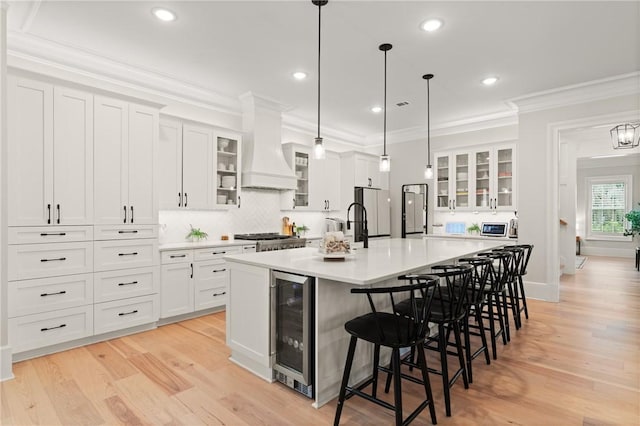 166 Robertson Cir, Saint Simons Island, GA 31522 - kitchen featuring wine cooler, a spacious island, white cabinetry, light countertops, and ornamental molding