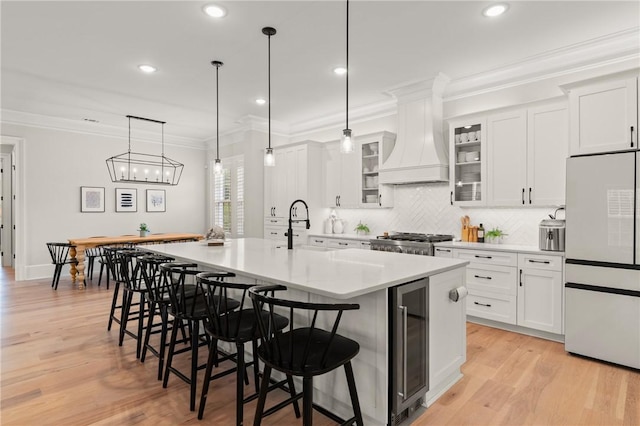 166 Robertson Cir, Saint Simons Island, GA 31522 - kitchen with white refrigerator, wine cooler, a kitchen bar, light countertops, and decorative backsplash