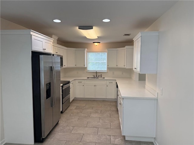 208 Stafford Ave, Brunswick, GA 31520 - kitchen featuring appliances with stainless steel finishes, light countertops, white cabinetry, and recessed lighting